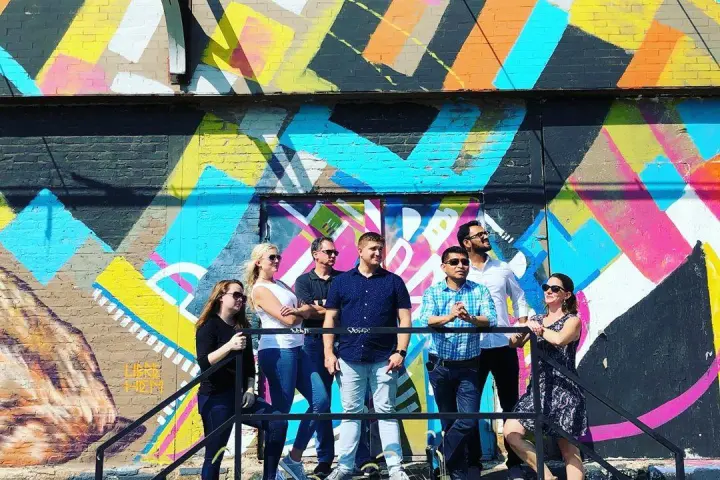 a group of people standing next to a painting